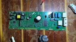 Foto einer Leiterplatte mit elektronischen Bauteilen auf einem Holztisch.