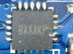 Nahaufnahme eines Chips mit der Aufschrift BAAAKP auf einer blauen Leiterplatte.
