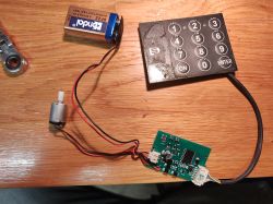 Moduł elektroniczny zamka sejfu z klawiaturą, płytką PCB i silnikiem na stole
