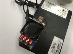 Black RouterUPS-30-POE UPS with a small fan module and red LED display placed on top