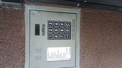 Domofon z klawiaturą numeryczną i listą nazwisk na ścianie budynku