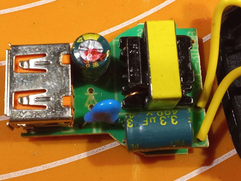 Zbliżenie wnętrza taniej ładowarki USB z elementami elektronicznymi