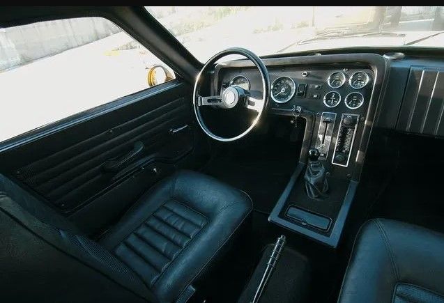 Wnętrze samochodu Anadol STC-16 z lat 70. z widocznym panelem sterowania i miejscem dla kierowcy.