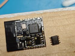 Close-up of a PCB with an antenna and a desoldered integrated circuit placed beside it