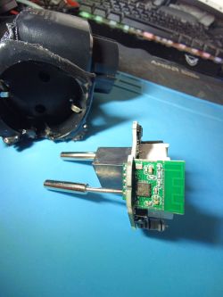 Plug with exposed electronic circuit board on a work surface Electrical plug with exposed circuit board on a blue mat, next to a disassembled black housing