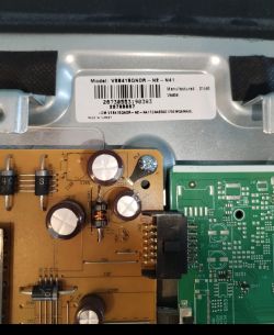 Close-up of circuit board with capacitors and a model label on the metal housing