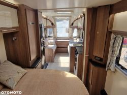 Interior of a caravan with wooden finishes and modern amenities.