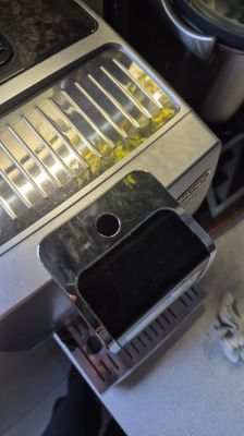 Zbliżenie na panel ekspresu do kawy DeLonghi Dinamica Plus ECAM 370.85B z zapadniętym przyciskiem włącz/wyłącz.