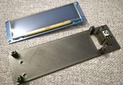 Graphic VFD display and 3D-printed black enclosure on fabric surface