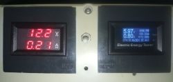 Two digital meters displaying voltage, current, and other electrical parameters.