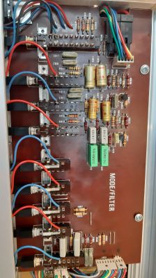 Płytka elektroniczna z różnymi komponentami, takimi jak rezystory, kondensatory i przewody.