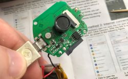 Close-up of a circuit board with a connected micro USB cable and a mounted camera lens.