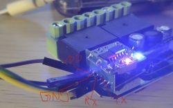 Close-up of a WiFi module with RF 433 MHz remote, showing GND, VDD, RX, and TX labels.