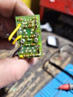 Płytka elektroniczna z kolorowymi przewodami i elementami lutowanymi.