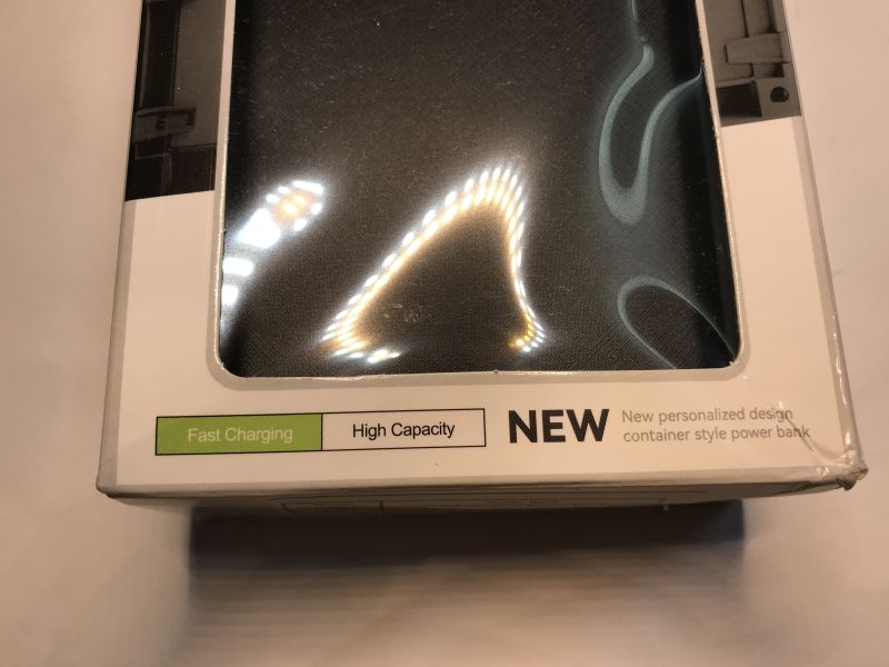 Close-up of a power bank box with window and labels “Fast Charging”, “High Capacity”, and “NEW”