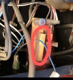 Elektronisches Bauteil auf einer Leiterplatte, mit einem roten Kreis markiert, von Kabeln umgeben.