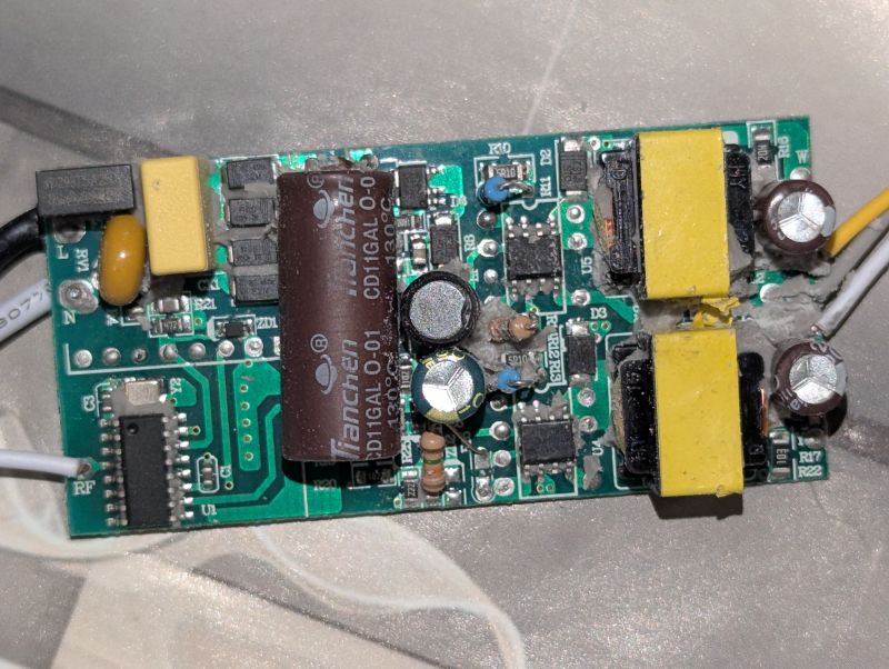 Zbliżenie na płytkę PCB z elementami elektronicznymi, w tym kondensatorami i transformatorami