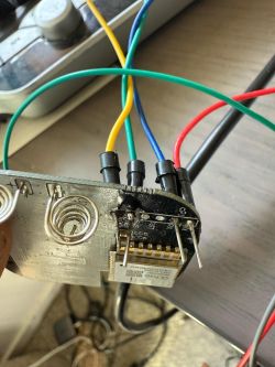 Electronic board with connected wires and visible programming pins.