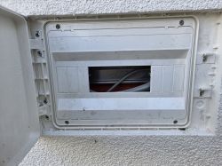 Zamontowana rozdzielnica elektryczna IP65 w ociepleniu elewacji z widocznymi przewodami