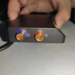 Close-up of DP100 power supply terminals with LED lights: blue (minus) and red (plus)