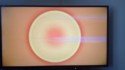 Ekran telewizora Toshiba z poziomymi paskami na żółtym tle.