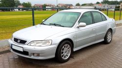 Srebrny sedan Honda Accord 6. generacji zaparkowany przy ulicy