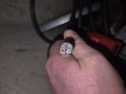 Osoba trzymająca w ręku kabel z widocznymi czterema żyłami.