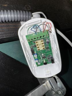 Widok wnętrza czujki alarmowej Satel Dual Slim z okablowaniem i płytką obwodów.
