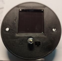 Widok z góry na czarny panel solarny lampki ogrodowej z wyłącznikiem i diodą LED