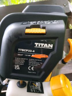 Zbliżenie na korpus kosy spalinowej Titan TTBCP33-4 z widoczną etykietą informacyjną
