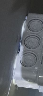 Zbliżenie na plastikową puszkę elektryczną zamontowaną blisko wanny.