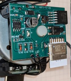 Close-up of a PCB with Wi‑Fi module, push button, 220 µF 10 V capacitor, and LM2596S regulator