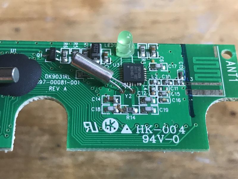 Płytka drukowana z komponentami elektronicznymi i antenką na zielonym tle.