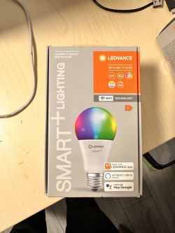 Ledvance SmartPlus Classic A100 14W Multicolor Packaging Packaging of Ledvance SmartPlus Classic A100 14W Multicolor bulb on a table.