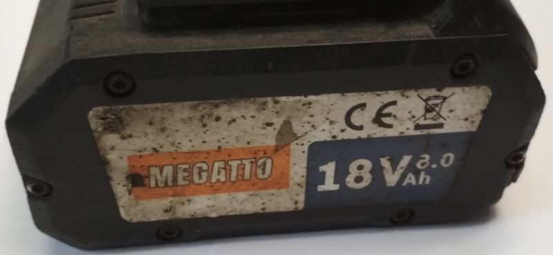 Brudny i zużyty akumulator Megatto 18V 8.0Ah z widocznymi śladami użytkowania i uszkodzoną etykietą.