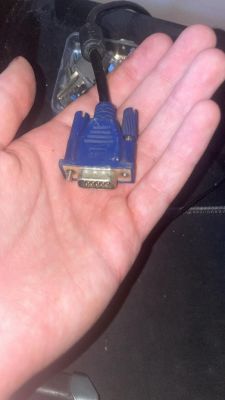 Ręka trzymająca niebieski kabel VGA.
