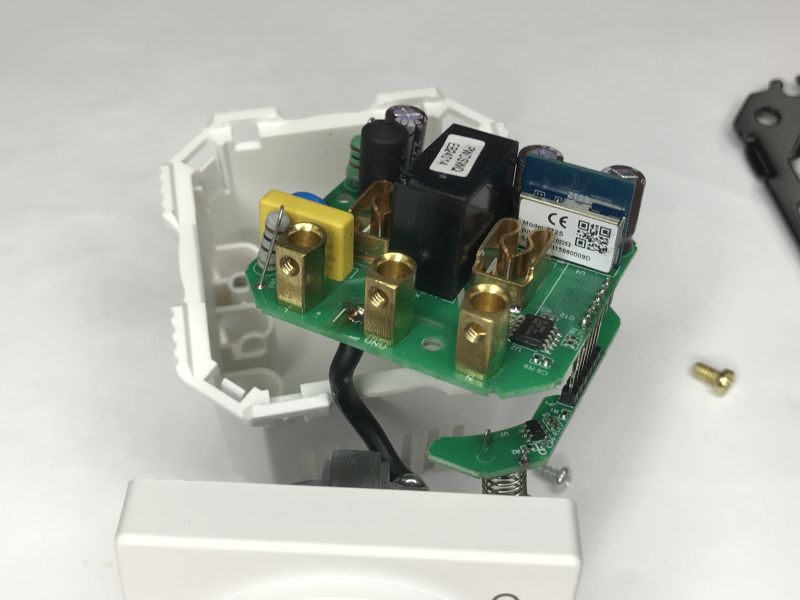 Inside a wall socket: PCB with screw terminals, relay, and a communication module in a white housing