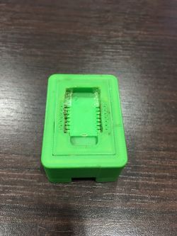 Green, 3D-printed plastic adapter for flashing firmware on ESP8266.