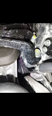 Zdjęcie wnętrza komory silnika z przewodami i częściami, które wyglądają na uszkodzone lub niepoprawnie zamontowane.