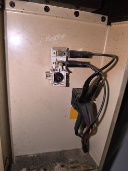 Wnętrze otwartego grzejnika z widocznymi przewodami i złączem elektrycznym.