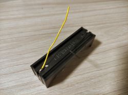 Battery Holder with Soldered Yellow Wire Battery holder with attached yellow wire.