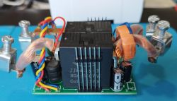 Close-up of an electronic component with copper wires and capacitors on a circuit board.