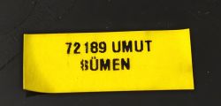 Yellow label with black text “72189 UMUT BÜMEN” on a dark background