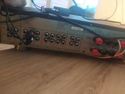 Tył wzmacniacza audio z różnymi portami i podłączonymi kablami.