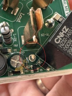 Close-up of a PCB with a missing through-hole component marked in red