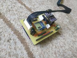 Electronic module on a PCB with connected cables and components, including an ESP32 and an SD card reader.