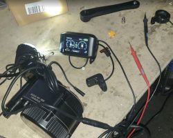 Nowy silnik elektryczny do roweru z wyświetlaczem i akcesoriami na stole warsztatowym.