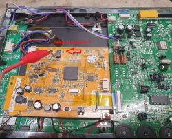 Zdjęcie wnętrza urządzenia elektronicznego z widoczną płytką z układami scalonymi. Czerwona strzałka wskazuje na komponent, obok którego jest zaznaczone pytanie: Jakie napięcie?.
