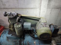 Sprężarka powietrza z elementami mechanicznymi i elektrycznymi, zamontowana na niebieskiej butli.