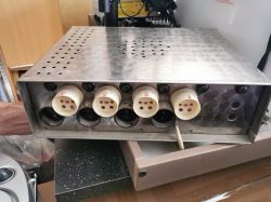 Metalowa obudowa urządzenia elektronicznego z sześcioma dużymi gniazdami na przednim panelu, opisanymi numerami.